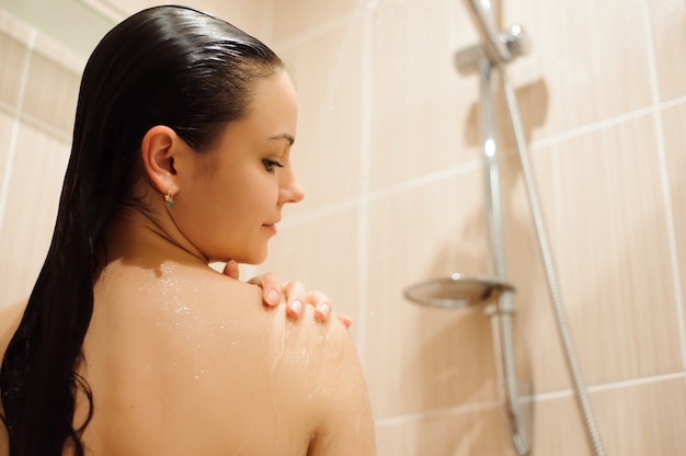 Fille sous la douche dans la cabine de cabine de douche