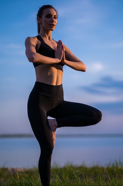 Fille de sport faisant du yoga sur la plage