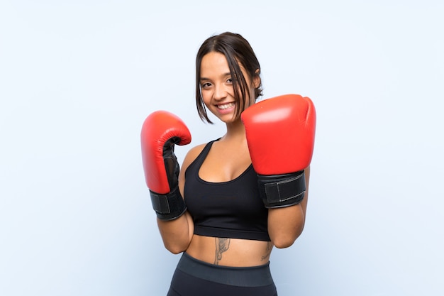 Fille De Sport Jeune Avec Des Gants De Boxe Sur Mur Bleu Isolé