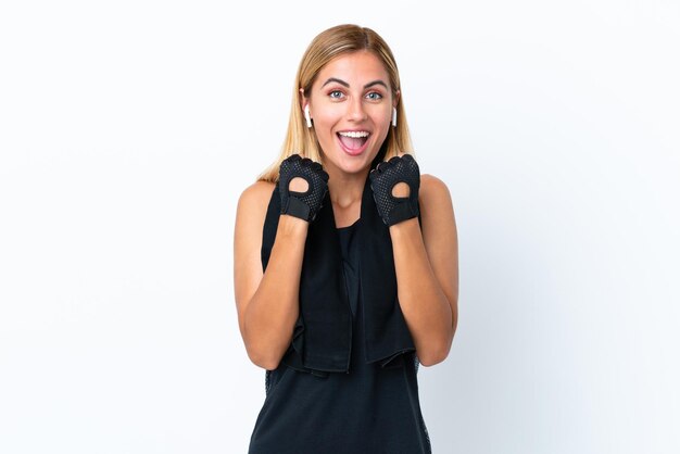 Fille de sport uruguayenne blonde isolée sur fond blanc célébrant une victoire en position de vainqueur