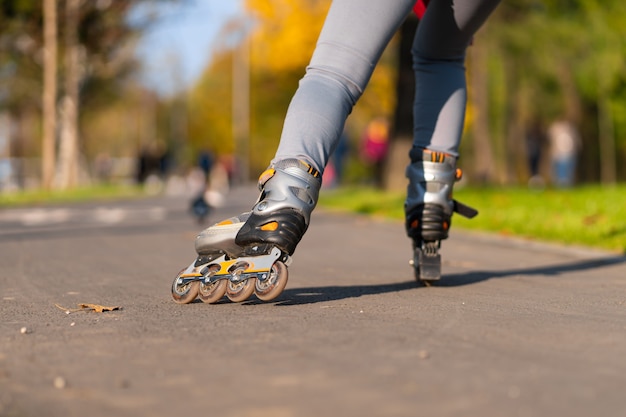 Une fille sportive fait du roller dans un parc d'automne