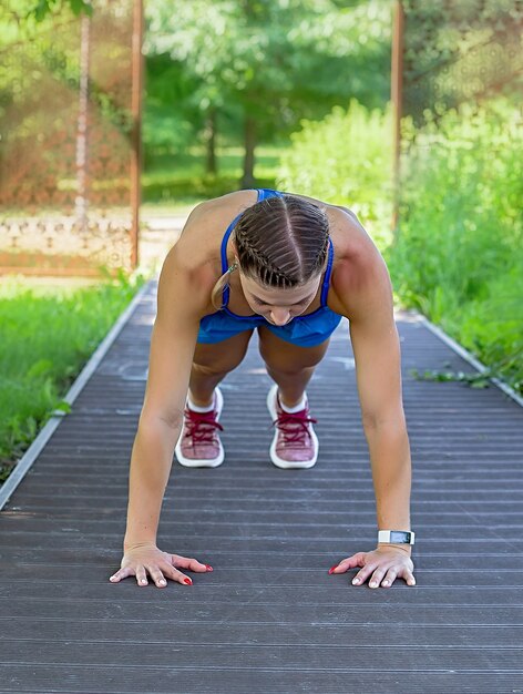 Fille sportive fait une planche dans le parc