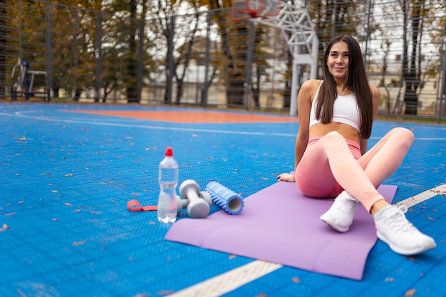 Fille sportive reposant sur un tapis de fitness