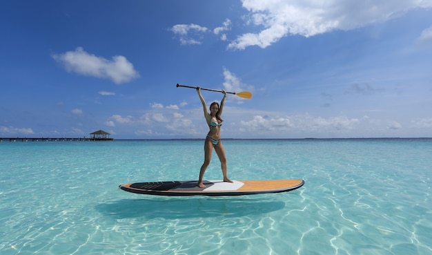 Fille de surf SUP aux Maldives