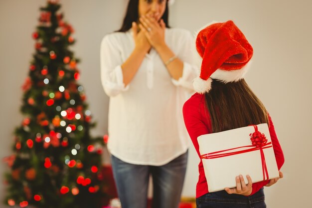 Photo fille surprenant sa mère avec un cadeau de noël