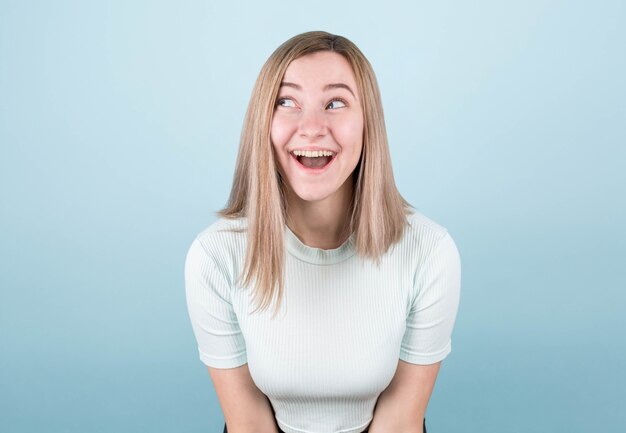 Fille surprise dans un haut bleu sur fond bleu