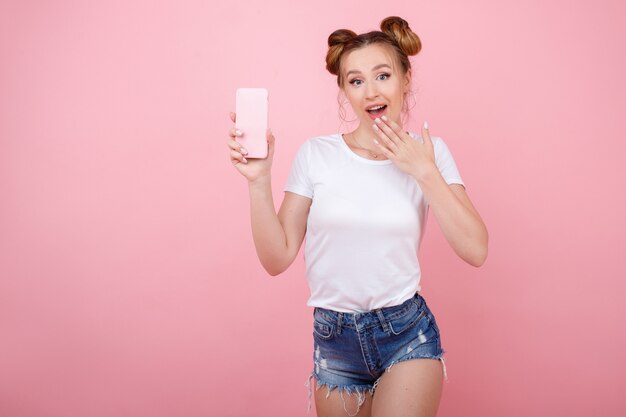 Fille Surprise Avec Un Téléphone Sur Un Espace Rose