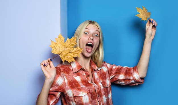 Fille surprise en tenue décontractée avec des feuilles d'érable femme blonde avec des feuilles tendances de la mode pour l'automne
