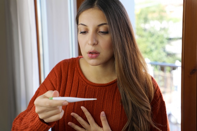 Fille avec un symptôme d'essoufflement de la maladie à coronavirus 2019 contrôle la fièvre.