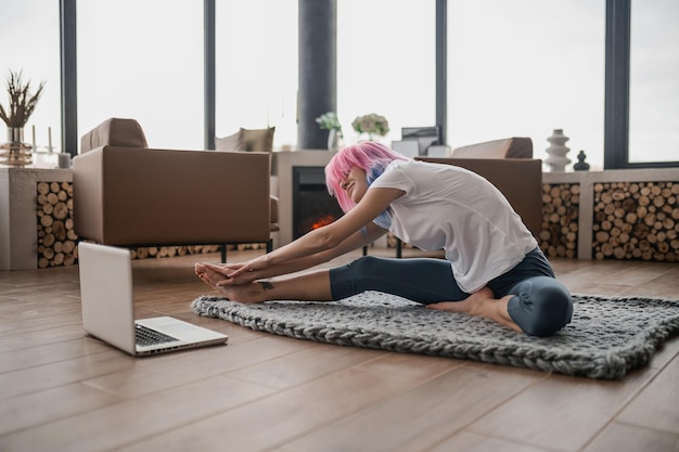 Une fille en t-shirt blanc faisant des exercices du matin