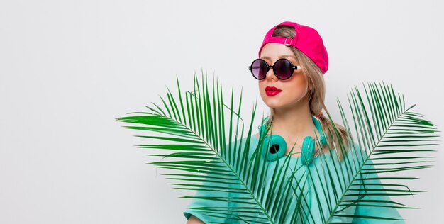 fille en t-shirt avec branche de palmier vert