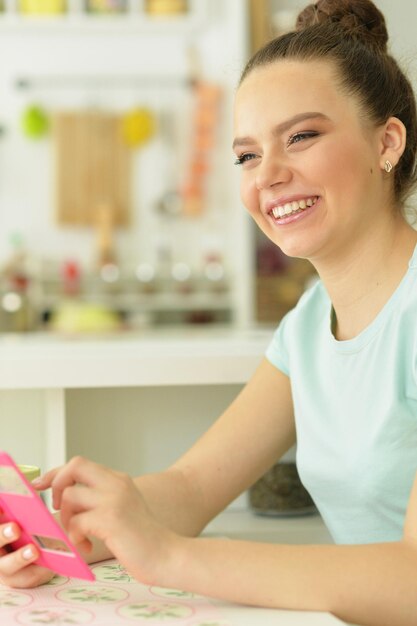 Fille à la table avec le téléphone