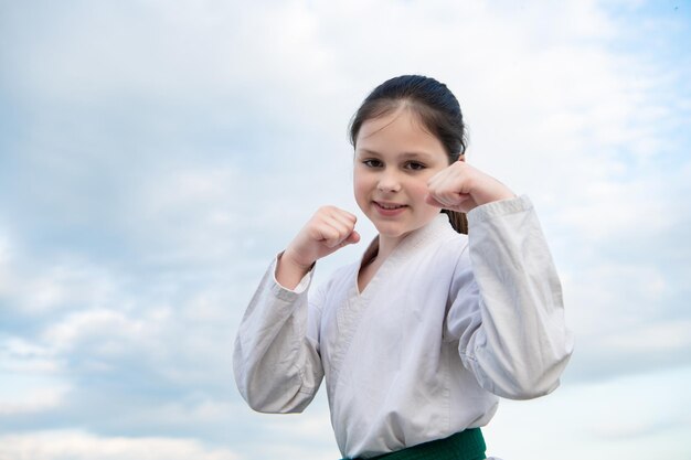 Fille de taekwondo en kimono sur fond de ciel