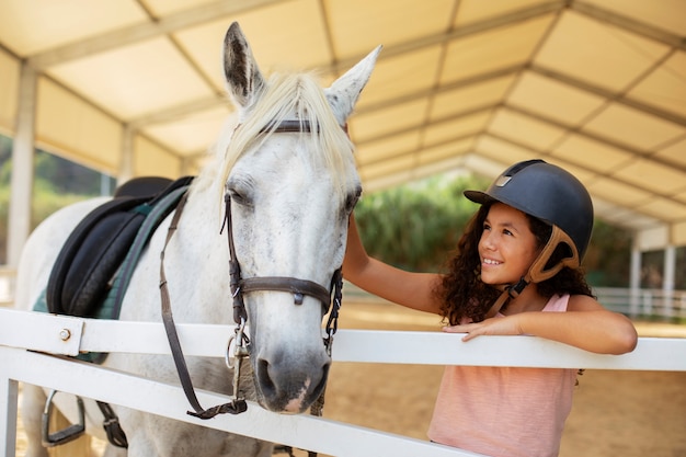 Une fille de taille moyenne avec un beau cheval.