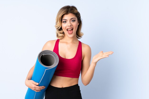 fille avec tapis isolé avec une expression faciale choquée