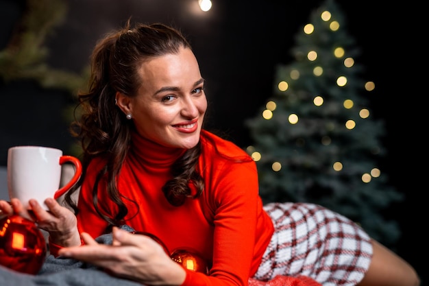 Fille avec une tasse de boisson chaude relaxante Choses à faire avant Noël Femme avec tasse et fond de décorations de Noël Détendez-vous et rechargez-vous