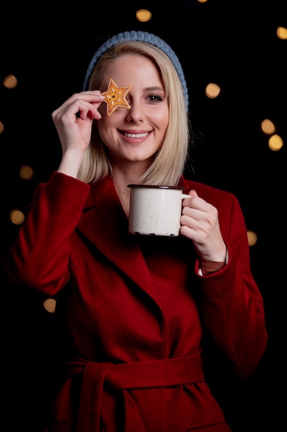 Fille avec tasse de café et biscuit de pain d'épice