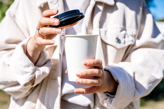 Fille avec une tasse de café à emporter Fille élégante tenant une tasse de papier avec une boisson chaude à l'extérieur