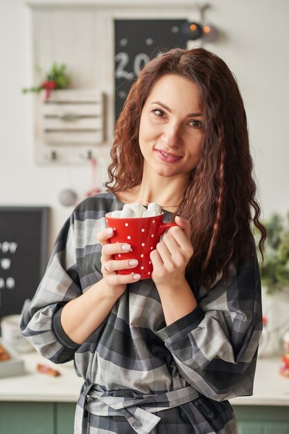 fille avec une tasse dans la cuisine du nouvel an