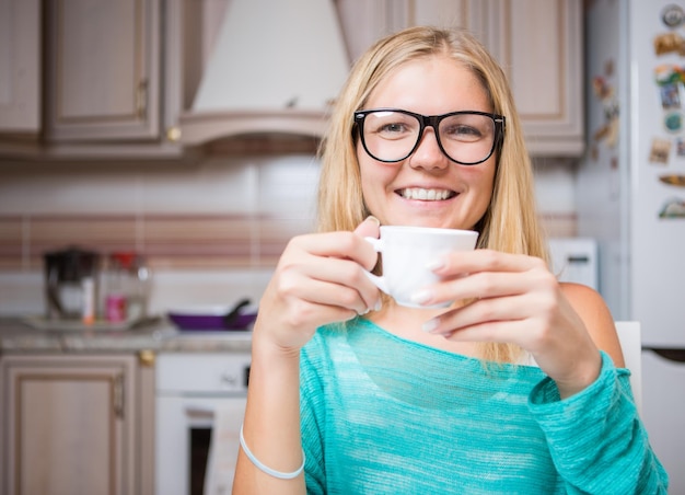 Fille avec tasse dans la cuisine