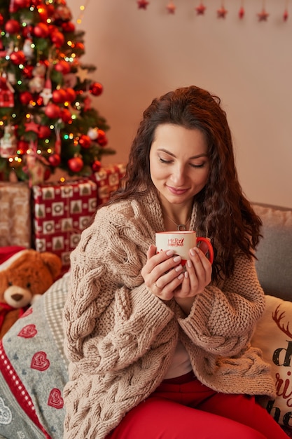 fille avec une tasse de guimauve à l'intérieur du nouvel an à la maison