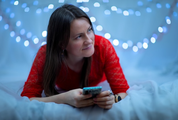 Fille avec un téléphone dans ses mains sur bokeh