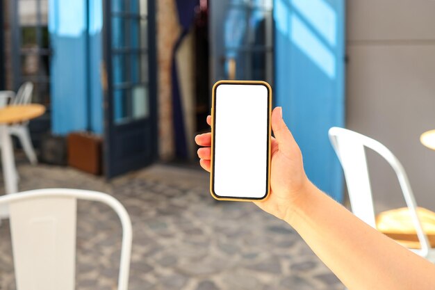 Fille avec un téléphone à écran dans un café dans la rue