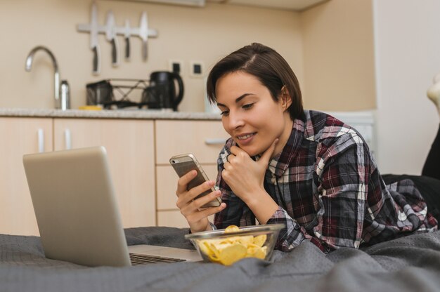 Fille, téléphone, lit, manger, chips