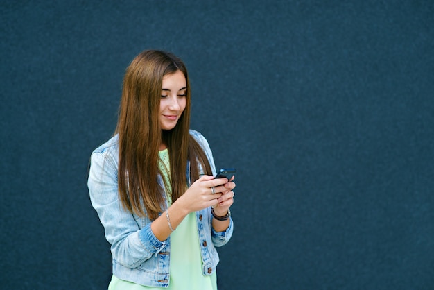 Fille avec téléphone en tapant du texte