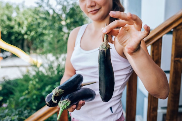 Fille tenant une aubergine dans ses mains. Alimentation saine, récolte.