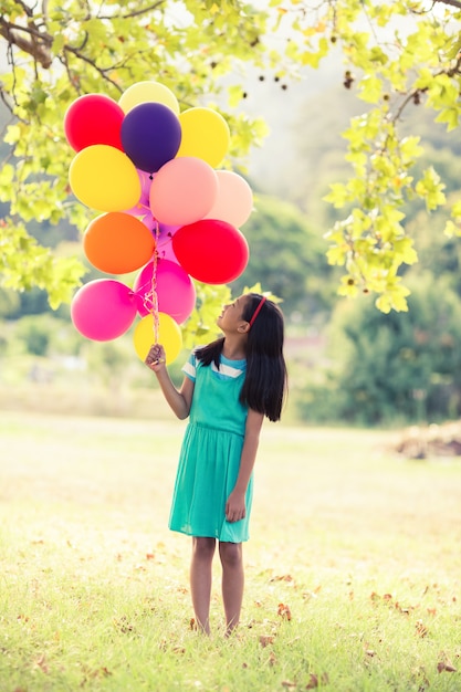 Fille tenant un ballon dans le parc