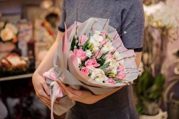 Fille tenant un beau bouquet de tulipes de couleur rose et renoncules blanches