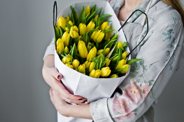 Fille tenant un bouquet de Tulipes jaunes.