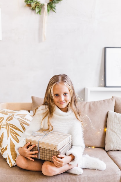 Fille tenant un cadeau pour Noël