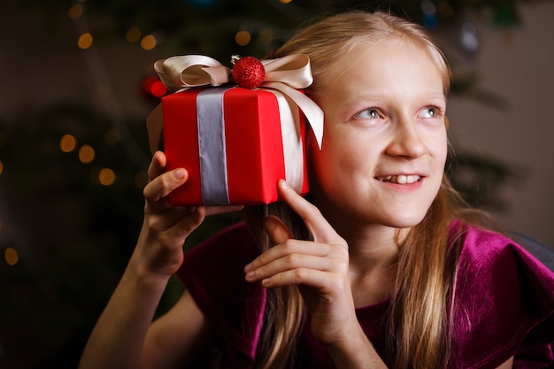 Fille tenant des cadeaux de Noël dans les mains Happy New Years