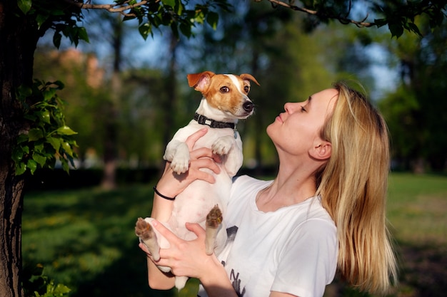 Fille tenant un chien dans les mains, jack russell terrier