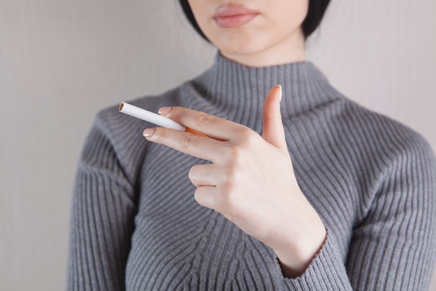 Fille tenant une cigarette à la main