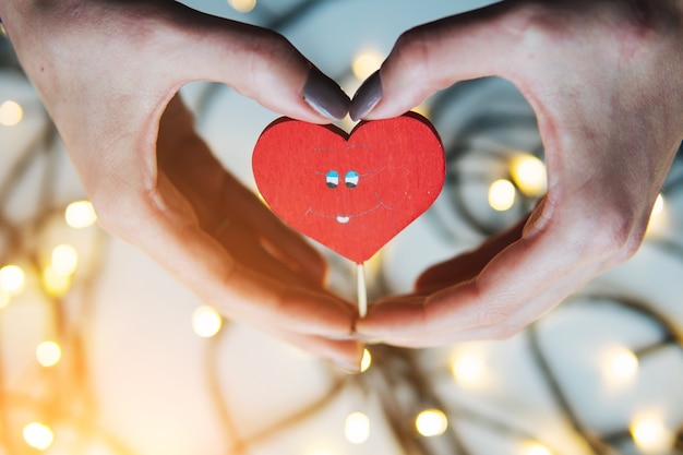 fille tenant un coeur rouge dans les mains