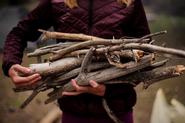 Fille tenant dans les mains un paquet de bois de chauffage