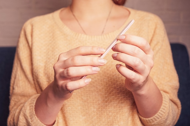 une fille tenant dans ses mains une lime à ongles