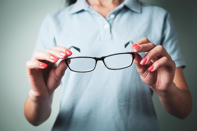 Fille tenant des lunettes à la main