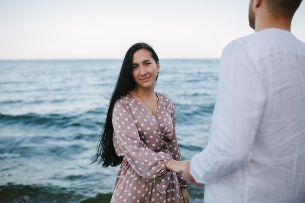 Fille tenant la main d'un mec sur la plage