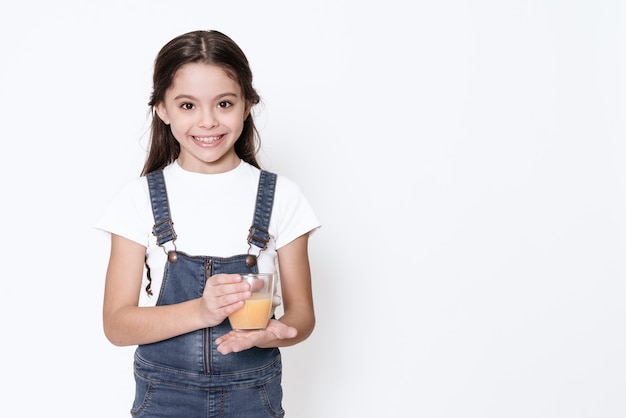 La fille tenant des médicaments et regarde dans la caméra.