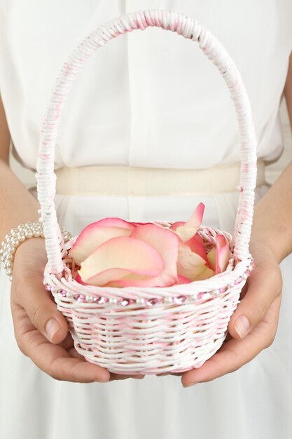 Fille tenant un panier de fleurs. Notion de mariage