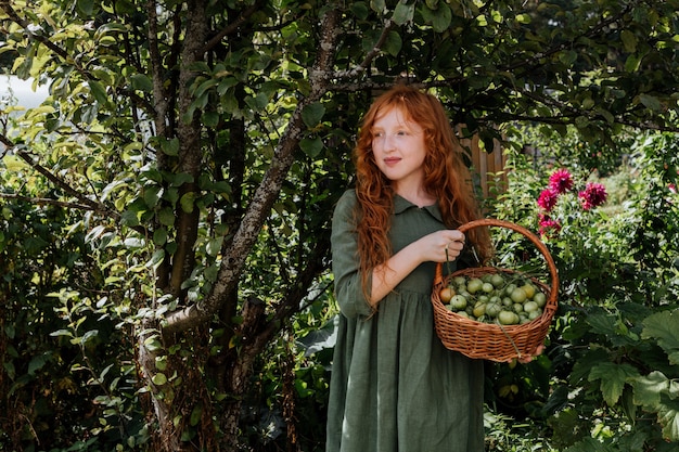 Fille tenant un panier de tomates vertes