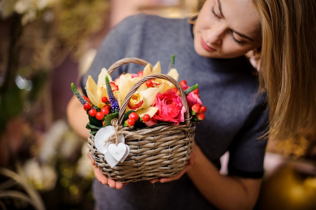 Fille tenant un petit panier de fleurs de printemps