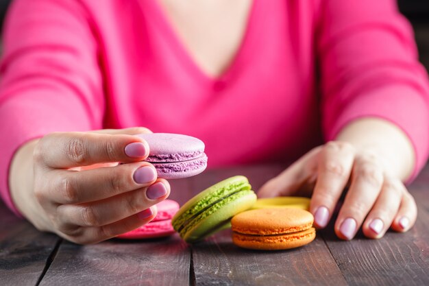 Fille tenant une tasse de café avec macaron