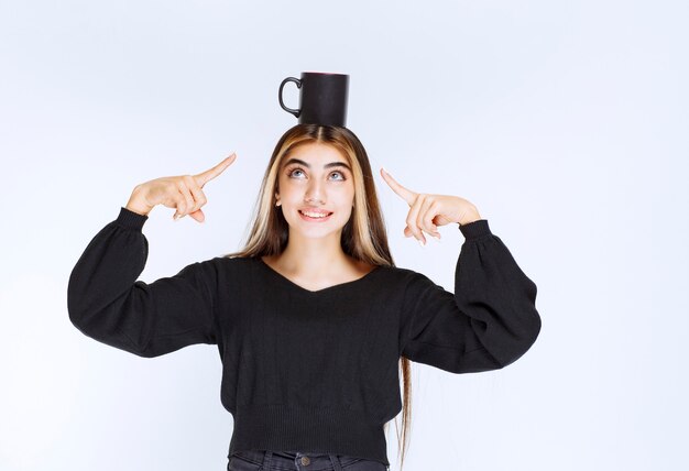 Fille Tenant Une Tasse De Café Noire à La Tête Et Se Sentant Satisfaite. Photo De Haute Qualité