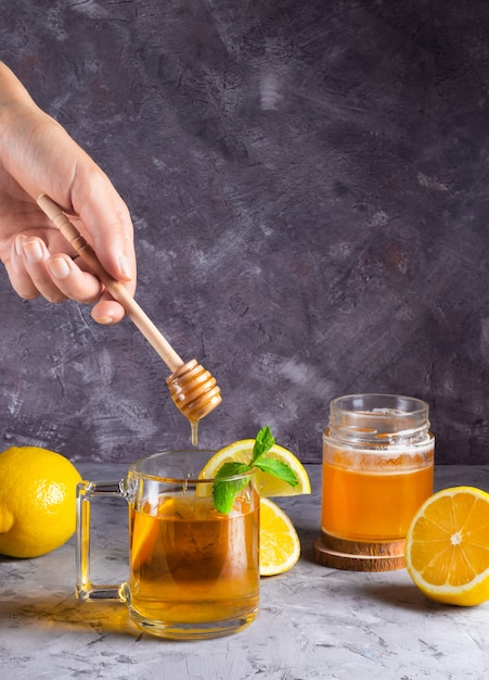 Fille tenant une tasse de thé au citron et miel