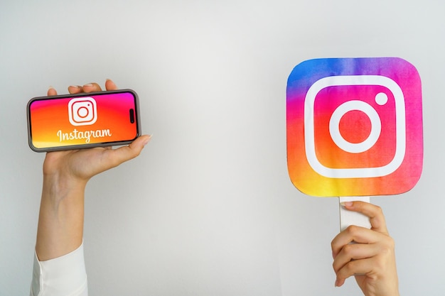 Une fille tenant un téléphone avec un logo Instagram et l'inscription Instagram
